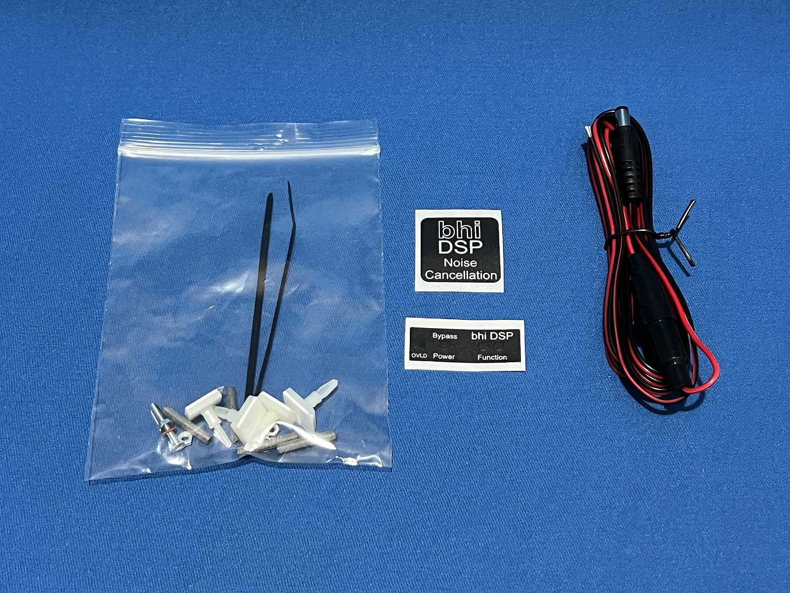 Flat lay of a black cable, bhi stickers and accessories